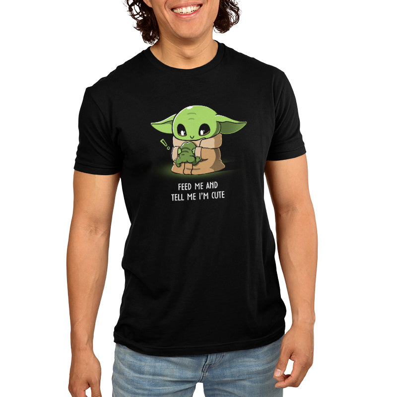 The Grogu is wearing a black Feed Me and Tell Me I'm Cute Star Wars t-shirt.
