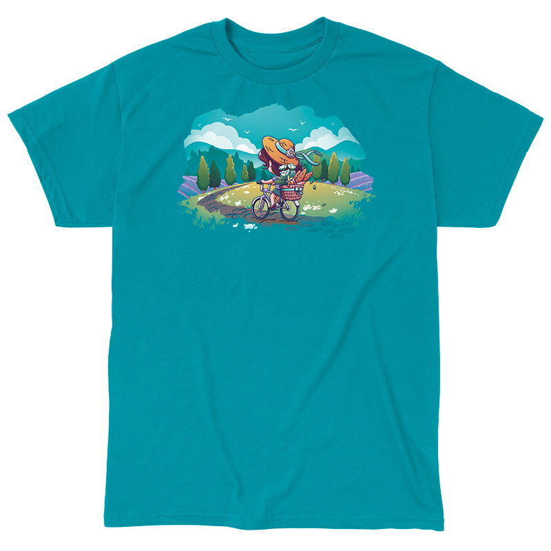 Classic Cotton T-shirt_TeeTurtle Countryside Biking tropical blue t-shirt featuring an illustration of a girl biking on a path in the countryside with bread and flowers in her basket. The path winds through rolling hills and fields of grass with small, white flowers. Green trees line the sides of the path, and lavender bushes are behind the trees, set against a light teal/turquoise sky, with fluffy white clouds and some birds.