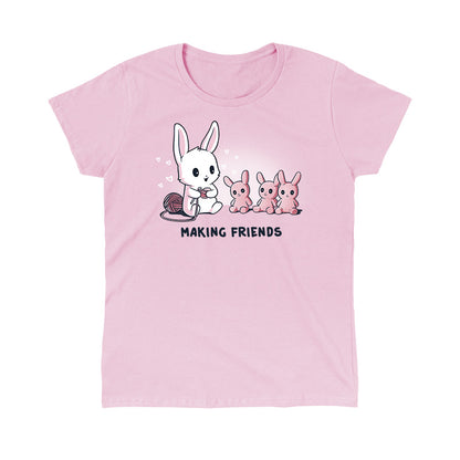 Classic Cotton T-shirt_Teeturtle Making Friends light Pink t-shirt Featuring a white-furred bunny knitting bunny friends out of yarn.