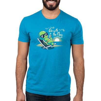 Premium Cotton T-shirt_Teeturtle Go with the Flow Cobalt Blue Featuring a turtle lounging on a beach chair with a tropical drink and sunglasses as the sun sets in the distance with the words 'Go with the Flow' to one side.