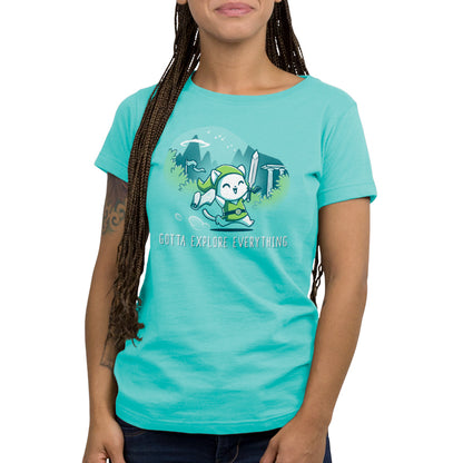 Premium Cotton T-shirt - Person wearing a Caribbean Blue apparelfeaturing a cartoon character dressed in explorer attire with a sword, surrounded by foliage and the text "Gotta Explore Everything." The super soft ringspun cotton adds extra comfort to this adventurous design from monsterdigital.