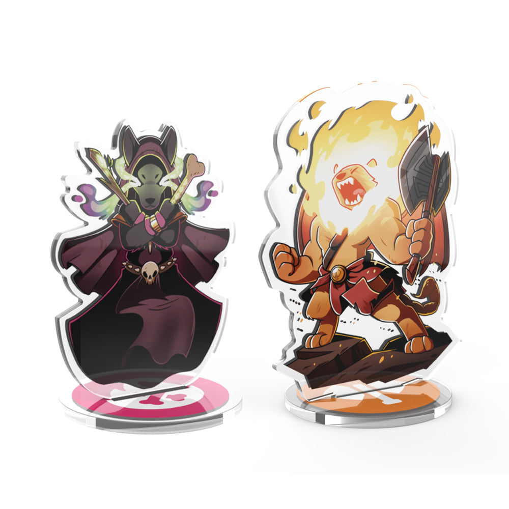 Two stylized acrylic standees: a dark-cloaked figure with green skin and a fiery character wielding a sword, both on clear stands from the Here to Slay: Berserker & Necromancer Expansion Standee Set by Unstable Games.