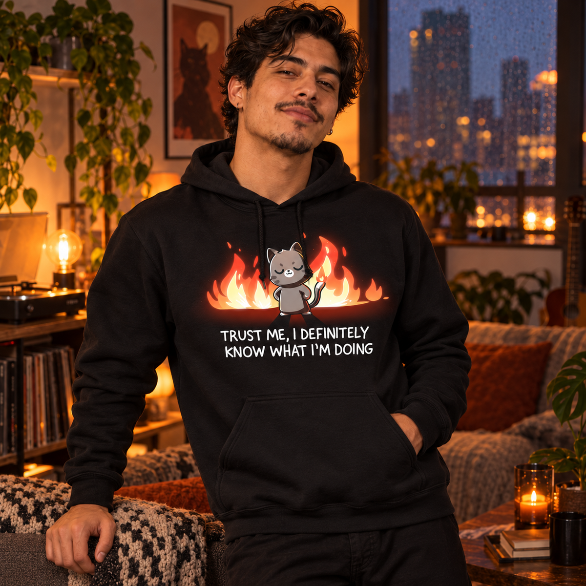 Pullover Hoodie_TeeTurtle black I Definitely Know What I'm Doing Pullover Hoodie featuring a smug gray cat standing confidently in front of bright flames with the text "Trust Me, I Definitely Know What I'm Doing."