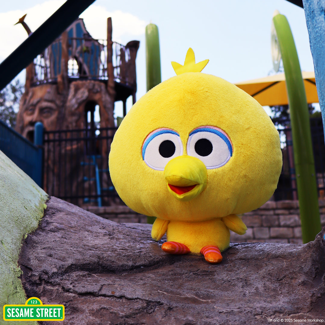 Cloudheads: 8" Big Bird sitting on a log with a playground in the background