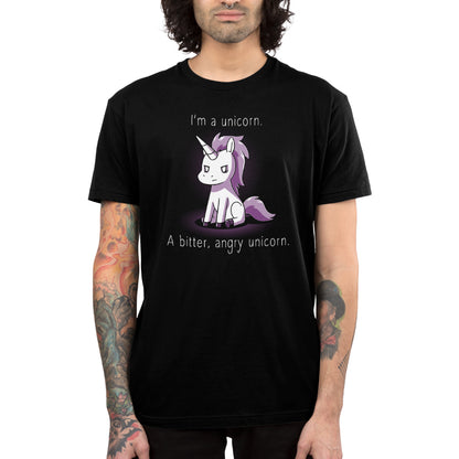 A person wearing an I'm a Bitter, Angry Unicorn T-shirt by monsterdigital in black super soft ringspun cotton, featuring an illustration of a frowning unicorn with text that reads, “I’m a unicorn. A bitter, angry unicorn.”.