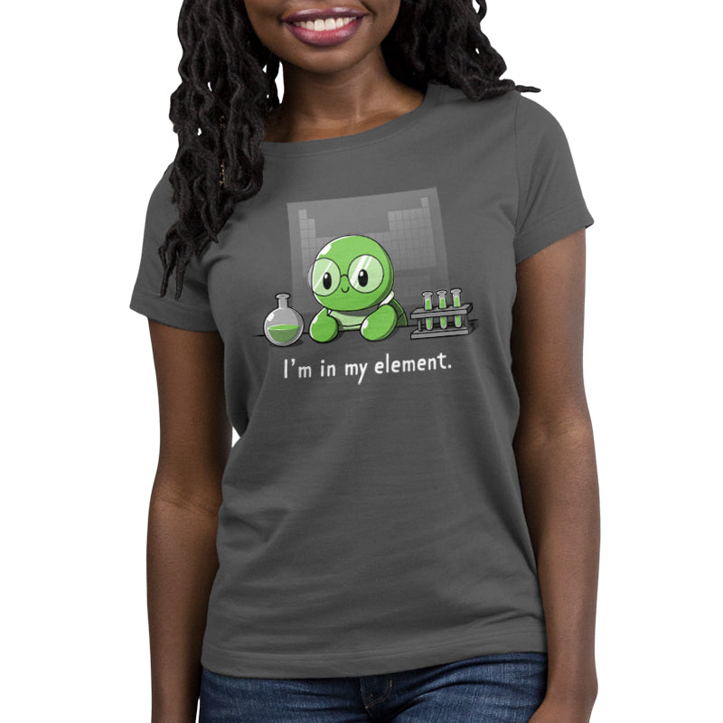 A person wears a charcoal gray "I'm in My Element" t-shirt from monsterdigital, featuring a green cartoon character holding a beaker and test tubes. Made from super soft ringspun cotton, this shirt combines comfort with geeky style.