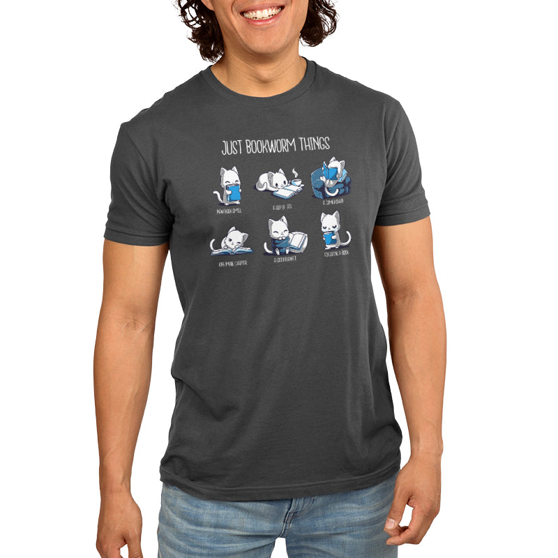 Person wearing a super soft ringspun cotton t-shirt in charcoal gray with illustrated cats and the text "Just Bookworm Things." The illustrated cats depict various book-related activities. Product Name: Just Bookworm Things, Brand Name: monsterdigital.