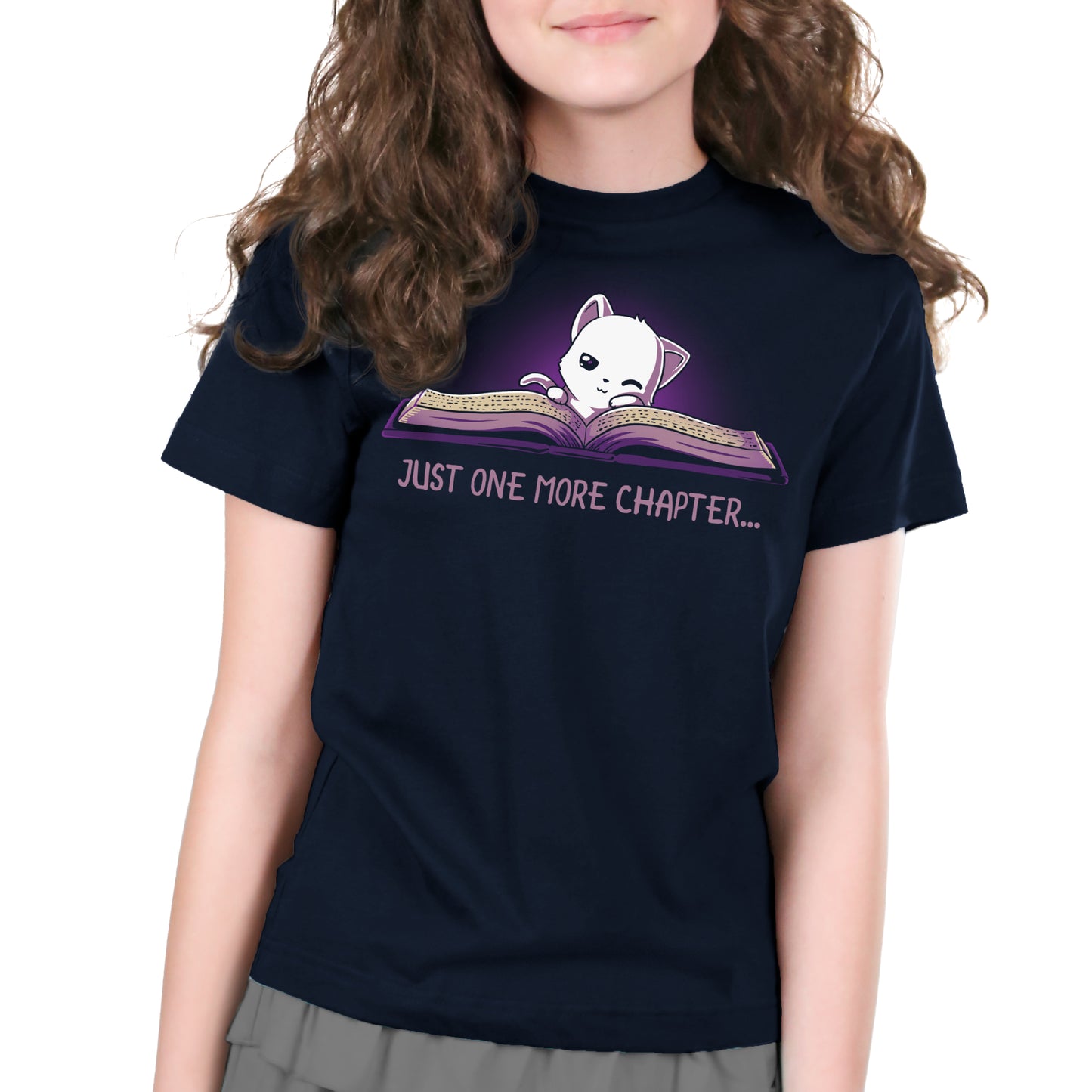 A girl wearing a navy blue Just One More Chapter T-shirt from TeeTurtle.