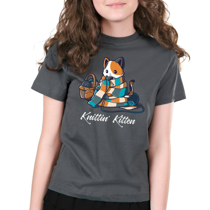 Premium Cotton T-shirt_TeeTurtle Knittin' Kitten charcoal gray t-shirt featuring a calico cat knitting a long scarf that’s wrapped around it with a basket of yarn next to it.