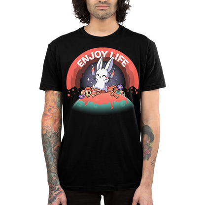 Premium Cotton T-shirt_TeeTurtle black Enjoy Life apparel featuring a bunny holding bloody knives in both paws, and skipping on a grassy hill littered with blood, bones, and purple flowers with a bloody rainbow in the background, and the caption, “Enjoy Life“.