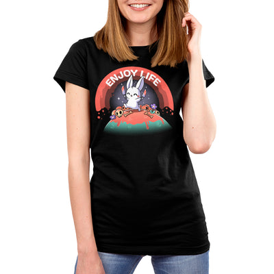 Premium Cotton T-shirt_TeeTurtle black Enjoy Life apparel featuring a bunny holding bloody knives in both paws, and skipping on a grassy hill littered with blood, bones, and purple flowers with a bloody rainbow in the background, and the caption, “Enjoy Life“.