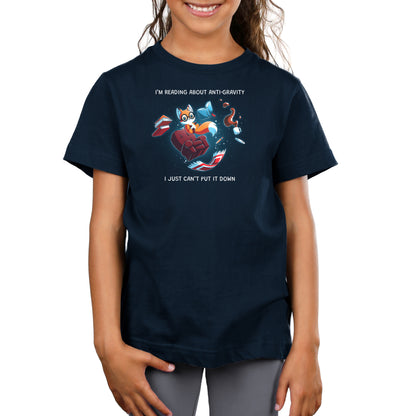 Premium Cotton T-shirt_TeeTurtle navy blue Anti-Gravity Enthusiast apparel featuring a fox wearing glasses reading a book with floating in mid-air with its living room furniture, such as a chair, rug, and lamp, with the caption, “I’m Reading About Anti-Gravity, I Just Can’t Put It Down“.