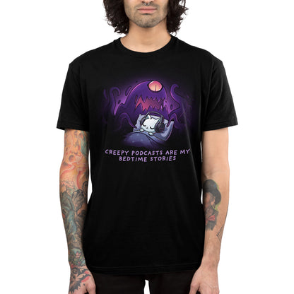 Premium Cotton T-shirt_TeeTurtle black Creepy Podcasts Are My Bedtime Stories apparel featuring a cat lying down in bed cozily wearing headphones with a giant purple monster looming over it and waving its tentacles.