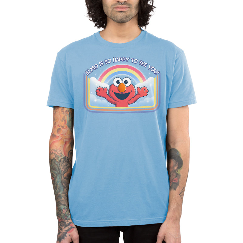 Premium Cotton T-shirt_TeeTurtle light blue Elmo Is So Happy To See You Premium Cotton T-shirt featuring Elmo from Sesame Street. He's smiling and has his arms wide as if he's going in for a hug. There's a rainbow and clouds behind him and  there is a retro style border along the sides and bottom. At the top is the text "Elmo Is So Happy To See You." 