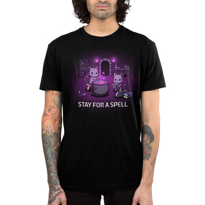 Premium Cotton T-shirt_TeeTurtle black Stay For A Spell apparel featuring two black cats in a spooky dungeon with one cat on a stool stirring a large cauldron, and the other cat reading from a pile of spellbooks with books, witchcraft accessories, and potion-making equipment in the background.