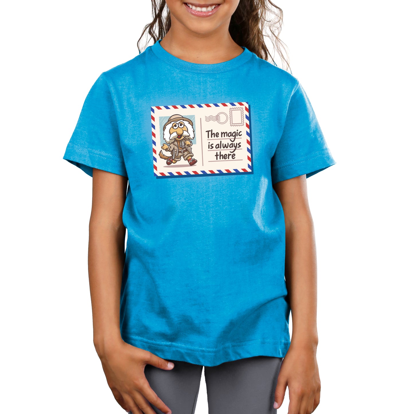 Premium Cotton T-shirt_TeeTurtle cobalt blue The Magic Is Always There apparel featuring Uncle Traveling Matt on a mail postcard with the caption on the underneath the stamp, “The Magic Is Always There“.