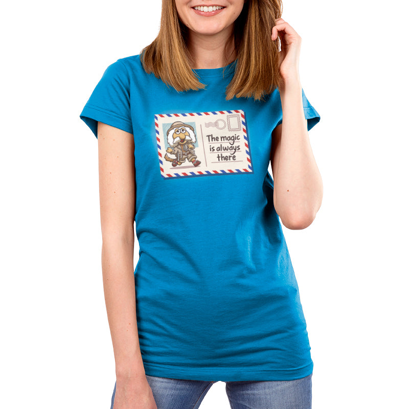 Premium Cotton T-shirt_TeeTurtle cobalt blue The Magic Is Always There apparel featuring Uncle Traveling Matt on a mail postcard with the caption on the underneath the stamp, “The Magic Is Always There“.