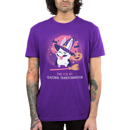 Premium Cotton T-shirt_TeeTurtle purple Time For My Seasonal Transformation apparel featuring a white bunny wearing a sparkling purple witch hat and cloak on top of a flying broom with a cauldron, bats, jack-o'-lantern, and the full red moon in the background.