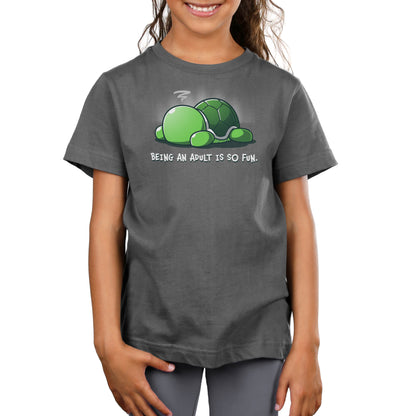 Premium Cotton T-shirt - A smiling child wearing a super soft ringspun cotton dark gray apparel with a cartoon turtle and the text "Being An Adult Is So Fun" by monsterdigital.