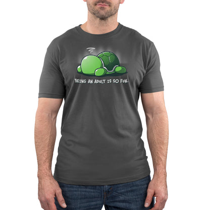 Premium Cotton T-shirt - A man wearing a charcoal gray apparelfeaturing a cartoon turtle lying on its back with the text, "Being an adult is so fun." This super soft ringspun cotton adult humor apparel from monsterdigital, named Being An Adult Is So Fun, perfectly captures the joys of grown-up life.