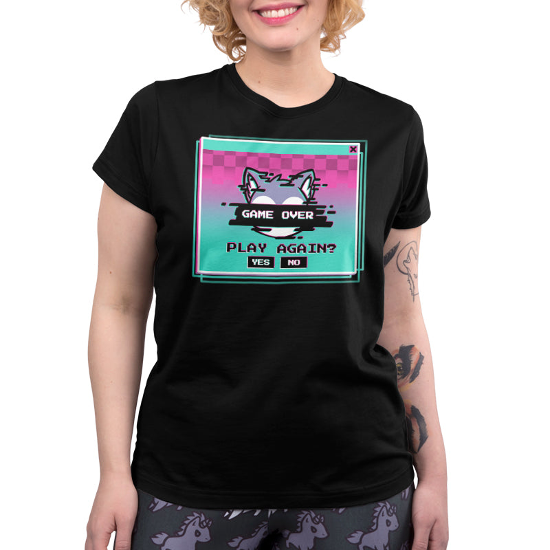 Person wearing a super soft ringspun cotton unisex tee from monsterdigital called "Game Over, Play Again?" with a pixelated "Game Over" screen design, including a "Play Again? Yes No" prompt, paired with pants decorated in patterns of unicorn heads.