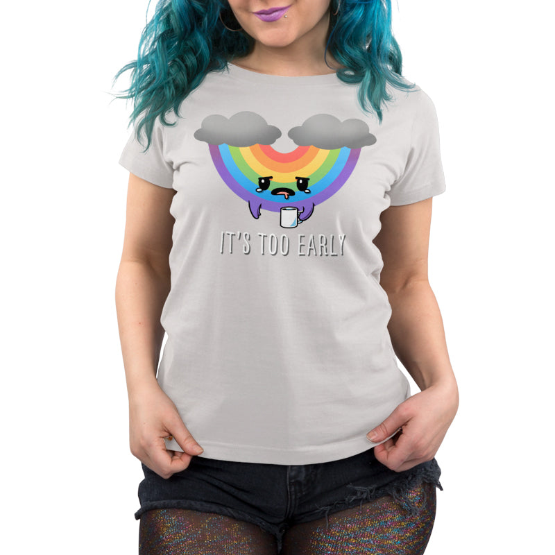 Premium Cotton T-shirt - Person wearing an **"It's Too Early" apparel** from **monsterdigital**, made of super soft ringspun cotton, featuring a sad cartoon rainbow between clouds. They have blue hair and are holding a coffee mug, sporting glittery shorts.