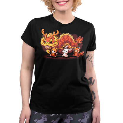 Person wearing a black, super-soft ringspun cotton T-shirt featuring a cartoon dragon and several small animals including rabbits and foxes standing in a row. The unisex tee, called "The Dragon Dance" by monsterdigital, is perfect for celebrating Lunar New Year. The individual has curly hair and visible tattoos on one arm.