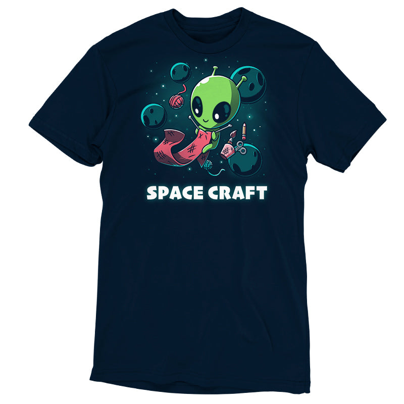 Premium Cotton T-shirt_TeeTurtle Space Craft navy blue t-shirt featuring an illustration of a green alien knitting a red scarf in space surrounded by planets, stars, balls of yarn, and a cup holding scissors, a paint brush and floating pencil. The words "SPACE CRAFT" are written below.