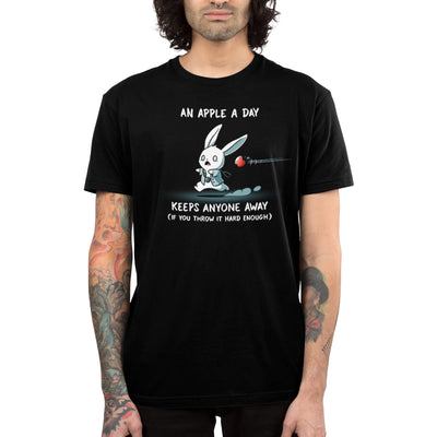 Premium Cotton T-shirt_TeeTurtle black An Apple A Day Keeps Anyone Away featuring a rabbit, dressed in a doctor uniform, running away from a flying apple. Text above reads, "an apple a day keeps anyone away," and below, "(if you throw it hard enough)."