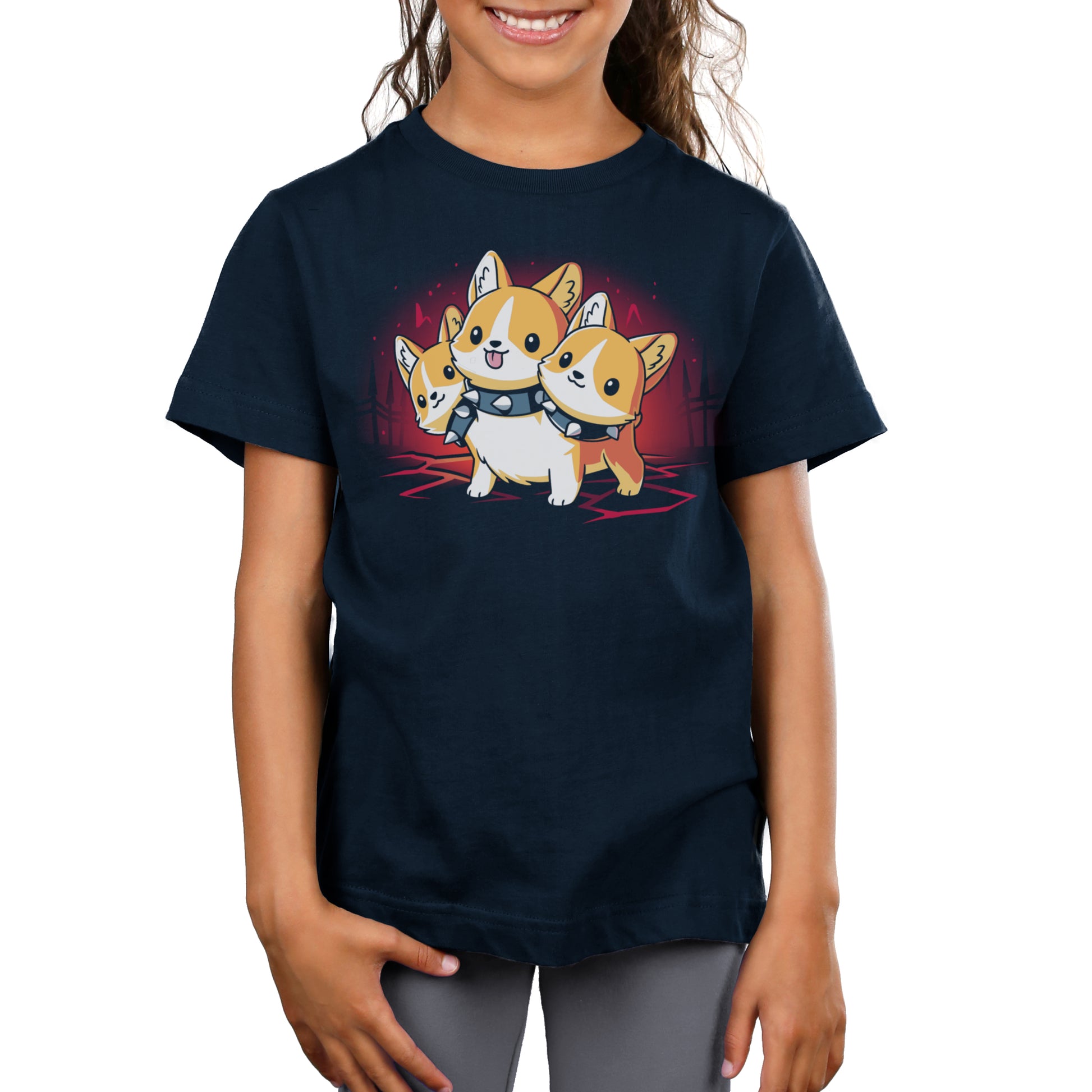 Girl wearing a navy blue t-shirt made from super soft ringspun cotton, featuring Monsterdigital's Corgi Cerberus against a red background.