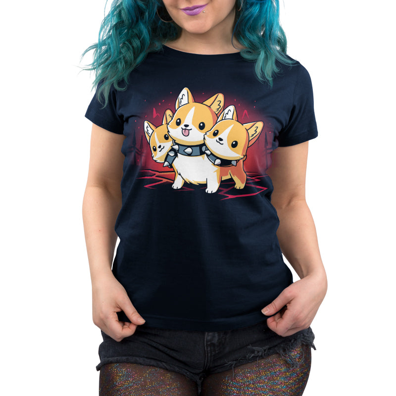 Person wearing a monsterdigital Corgi Cerberus super soft ringspun cotton navy blue T-shirt with a graphic of three corgi dogs dressed as astronauts, resembling a Corgi Cerberus. The person has teal hair and is standing with hands lightly grasping the sides of the shirt.