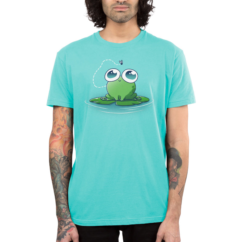 Premium Cotton T-shirt_TeeTurtle Eyes On The Prize Caribbean Blue t-shirt featuring a sweet & kawaii frog with big eyes sitting on a lily pad and staring at a fly above them.