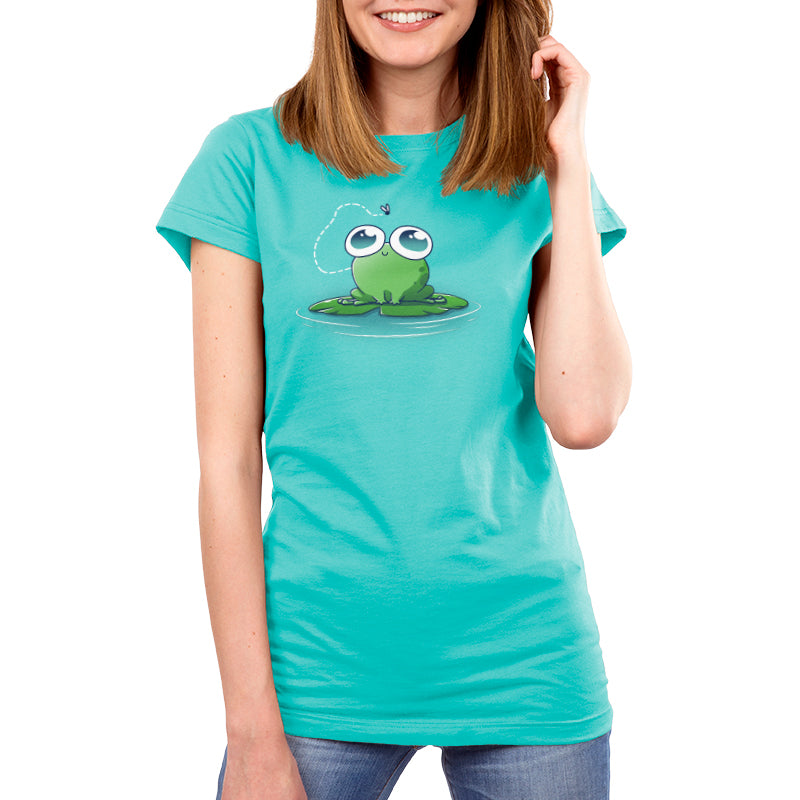 Premium Cotton T-shirt - A person wearing a Caribbean blue apparel with a cartoon frog and fly design, made from super soft ringspun cotton, stands against a white background. The product is called "Eyes On the Prize" by monsterdigital.