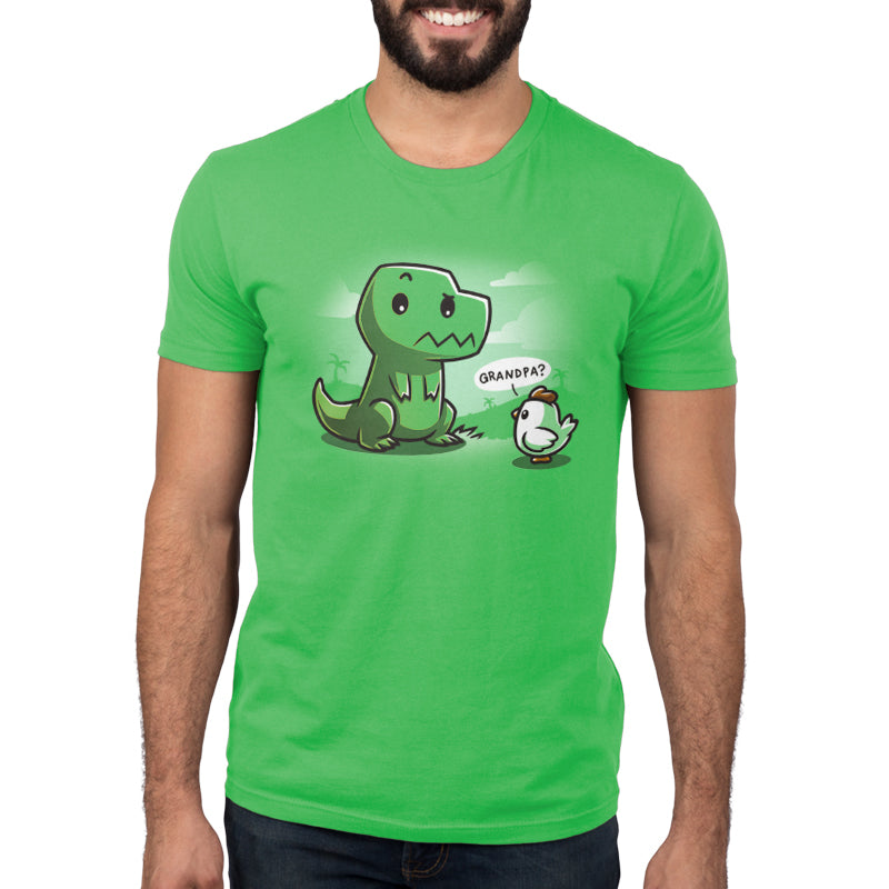 A person wears a super soft ringspun cotton green T-shirt featuring an illustration of a friendly cartoon dinosaur and a small bird with a speech bubble that reads "Grandpa?", called Family Reunion by monsterdigital.