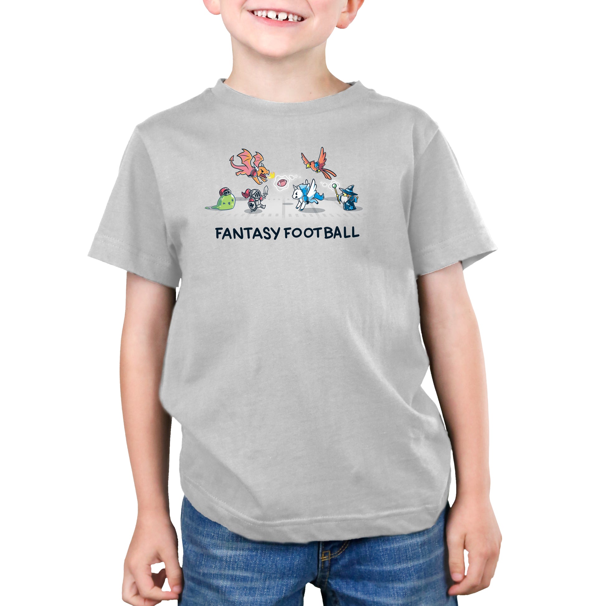 A young boy wearing a super soft ringspun "Fantasy Football" T-shirt by monsterdigital with colorful mythical creatures above the text stands against a plain white background.