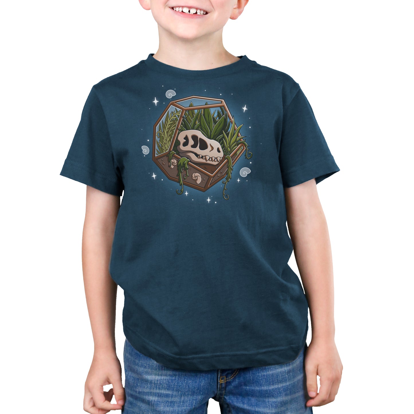 Premium Cotton T-shirt - A child wearing a dark blue Flora & Fossils apparel made of super soft ringspun cotton, featuring a graphic of a geometric terrarium with plants and a cow skull, standing with a slight smile.