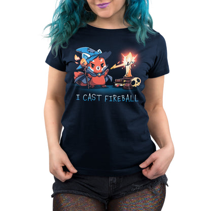 Person wearing a navy blue T-shirt made from super soft ringspun cotton, featuring a cartoon character casting a fireball spell. The text on the shirt reads "I CAST FIREBALL." The product is called I Cast Fireball by monsterdigital.