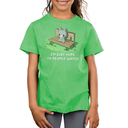 Premium Cotton T-shirt - A child wearing an apple green apparel depicting a cat on a bench with the text "I'm Just Here to People Watch" by monsterdigital, made of super soft ringspun cotton.