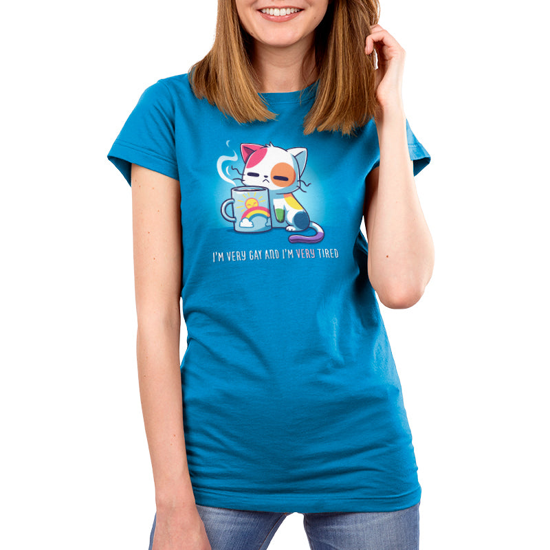Premium Cotton T-shirt - A person wearing a cobalt blue apparel featuring a cartoon cat holding a cup, with the text "I’m Very Gay and Very Tired" below the image. The apparel is from the brand monsterdigital.