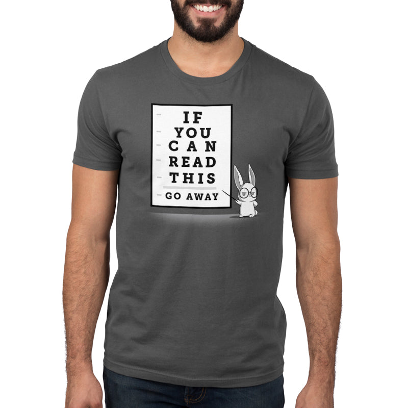 Premium Cotton T-shirt - A man wears a charcoal gray apparel with an eye chart design saying, "If You Can Read This, Go Away" and an illustration of a rabbit wearing glasses. This super soft ringspun cotton apparelby monsterdigital adds a playful touch to his casual look.