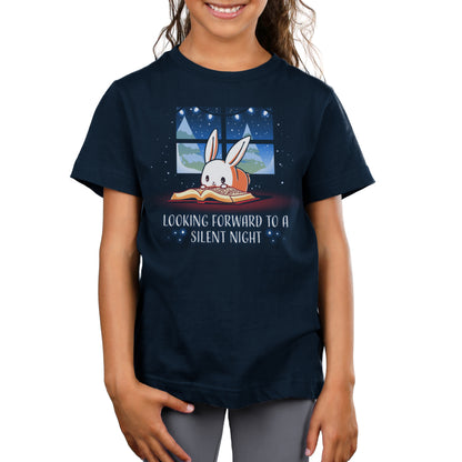 A child wears a super soft ringspun cotton, navy blue T-shirt with an illustration of a bunny sleeping under a window and the text "Looking forward to a silent night." The T-shirt is the "Looking Forward to a Silent Night" by monsterdigital.