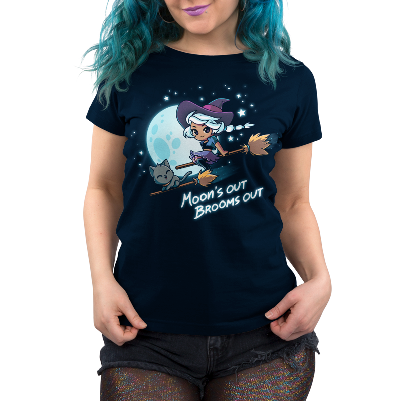 Premium Cotton T-shirt_TeeTurtle Moon's Out Brooms Out navy blue t-shirt featuring an illustration of a witch with light-gray hair, wearing a purple and dark-purple outfit and a dark purple witch's hat and a cartoon gray cat flying on two broom sticks past a full moon and starry sky. "Moon's OUT BROOMS OUT" is written underneath. 