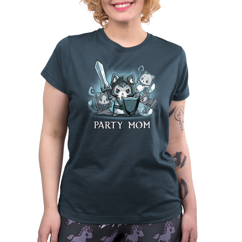 A person is wearing a monsterdigital Party Mom T-shirt made of super soft ringspun cotton, featuring a graphic design of a cat in armor holding a sword and shield, accompanied by smaller cats. They have curly hair and a tattoo on their forearm.