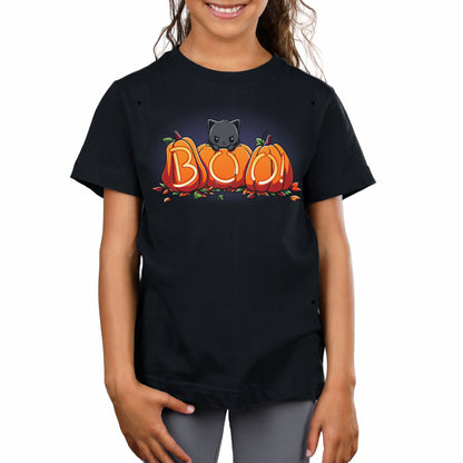 A girl stands smiling in her Pumpkin Kitty t-shirt by monsterdigital, a super soft ringspun cotton garment that perfectly captures the spooky season with a Halloween design featuring a black cat and pumpkins spelling "BOO.