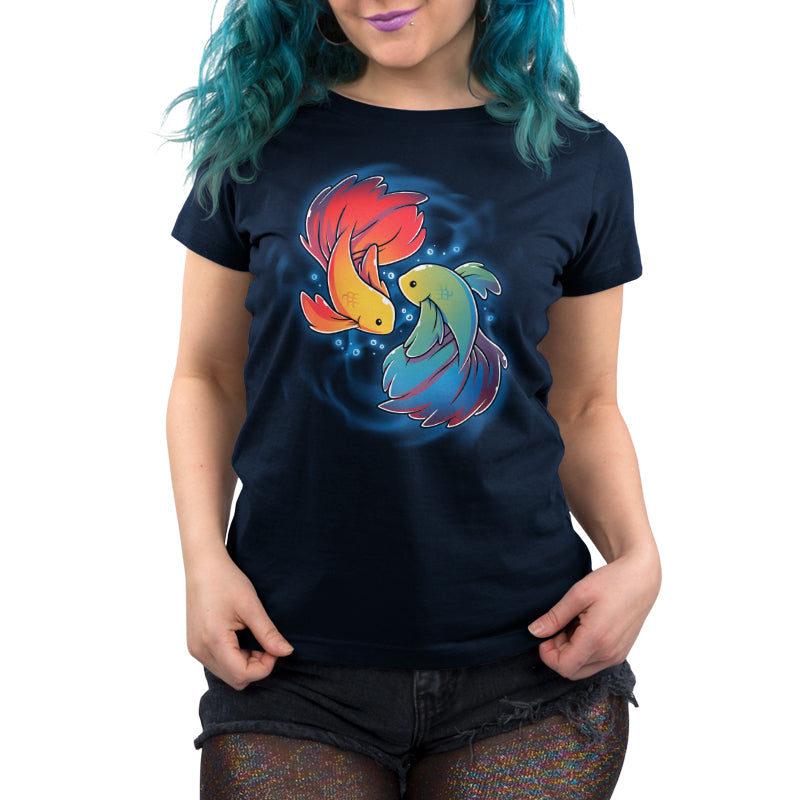 Person wearing a navy blue monsterdigital Rainbow Betta T-shirt made from super soft ringspun cotton, featuring artwork of two colorful Rainbow Betta fish, paired with shiny, multicolored leggings and frayed denim shorts.