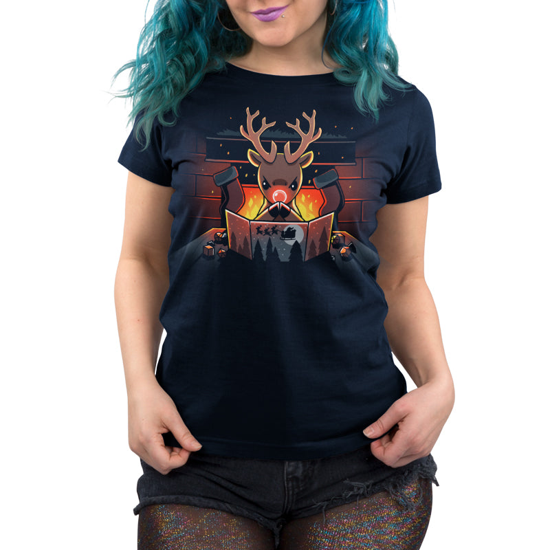 Person wearing a navy blue T-shirt made of super soft ringspun cotton with a reindeer in a Santa hat reading a book illustration, standing in front of a fireplace. The person has blue hair and holographic leggings. The T-shirt is called Reindeer Game Master by monsterdigital.
