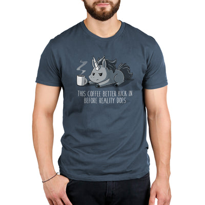 Premium Cotton T-shirt_Teeturtle denim blue Before Reality Kicks In apparel featuring a grumpy-looking unicorn on its stomach with a cup of steaming coffee in front of it. Caption reads 'This coffee better kick in before reality does".