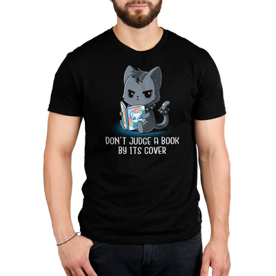 Premium Cotton T-shirt_TeeTurtle black Don't Judge a Book By It's Cover featuring seemingly grumpy, goth-looking cat wearing a spiked collar and spiked ring on its tail reading a bright, happy-looking rainbow-covered book above the text 'Don't Judge A Book By Its Cover'.