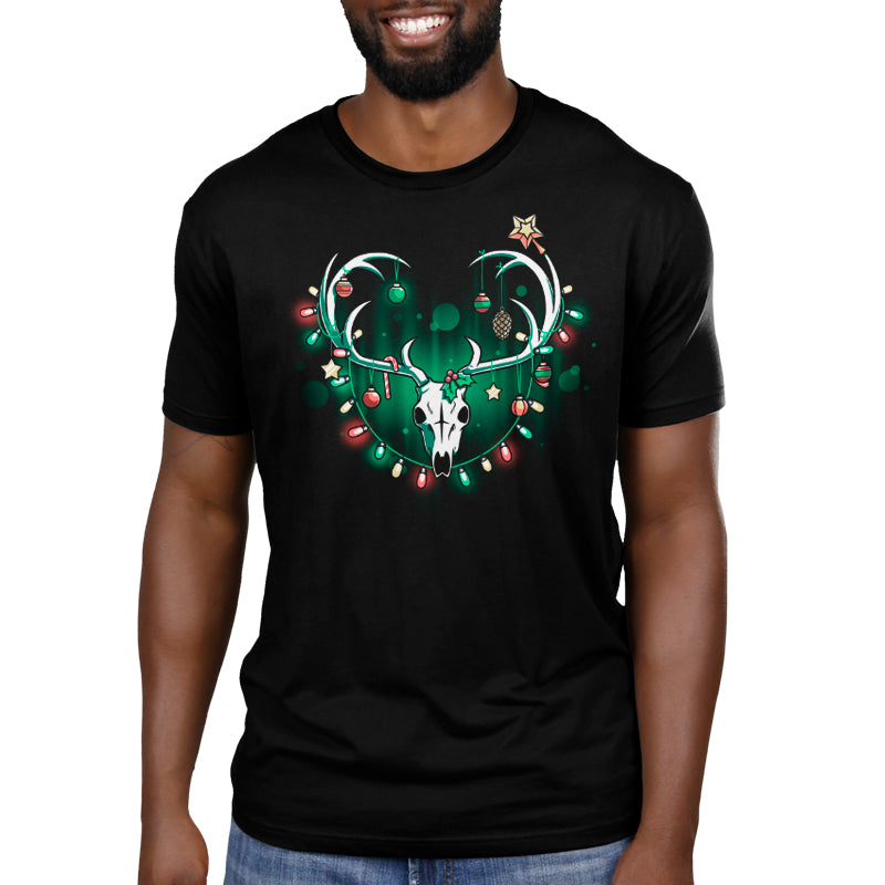 Premium Cotton T-shirt_TeeTurtle Haunting Holidays black t-shirt featuring an illustration of a white skull deer with its antlers decorated with red, yellow and green Christmas lights and ornaments such as small spheres, stars, pinecones, and candy canes.