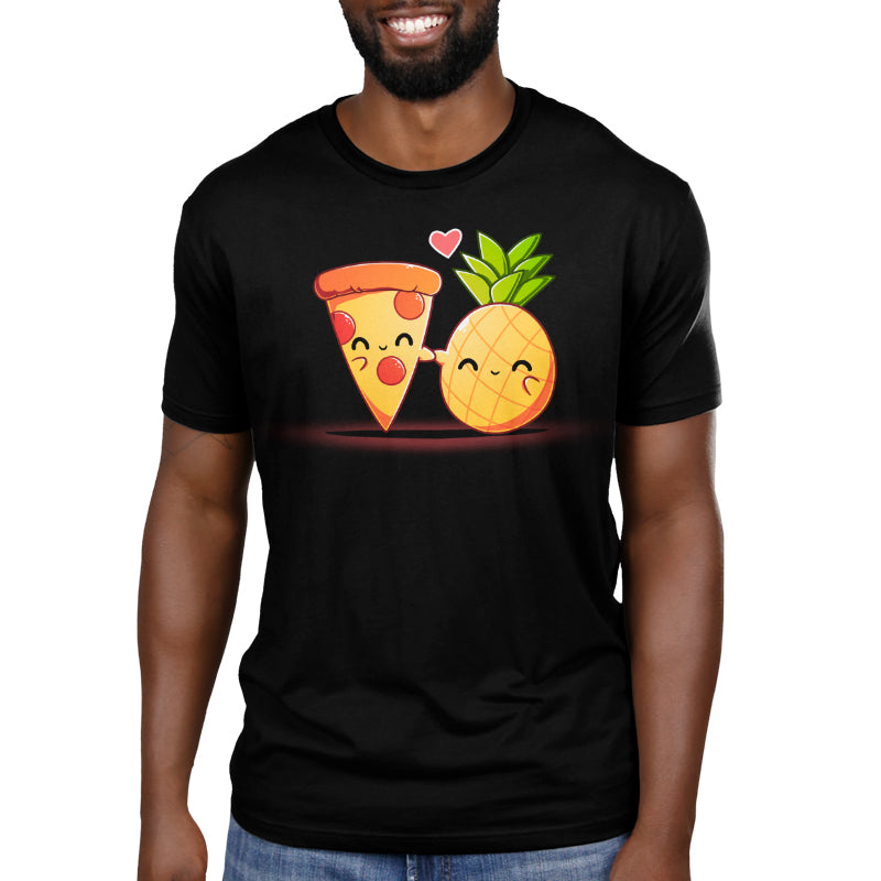 Premium Cotton T-shirt - A person is wearing a black 100% super soft ringspun cotton apparel, featuring a graphic of a smiling pizza slice and a pineapple holding hands with a heart above them. This unisex apparelfrom monsterdigital is perfect for fans of Hawaiian Pizza.